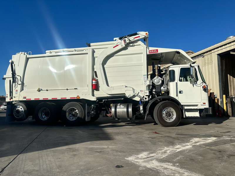 Side view of Heil front loader refuse truck