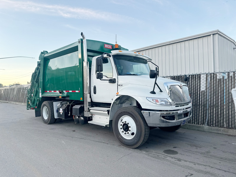 International rear loader refuse truck with green body